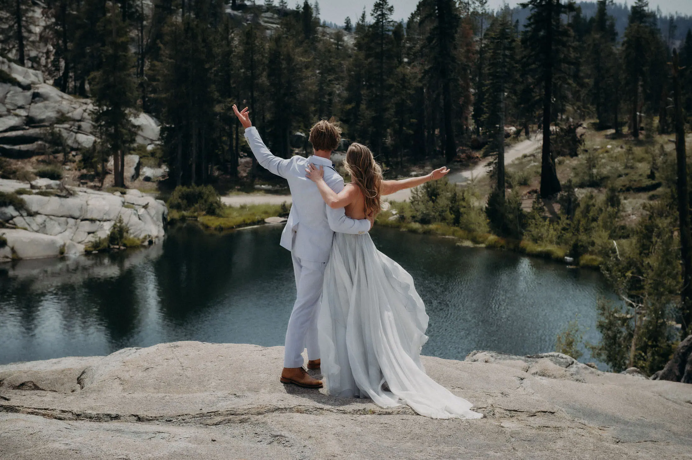 A couple on the polished granite above the private lake.