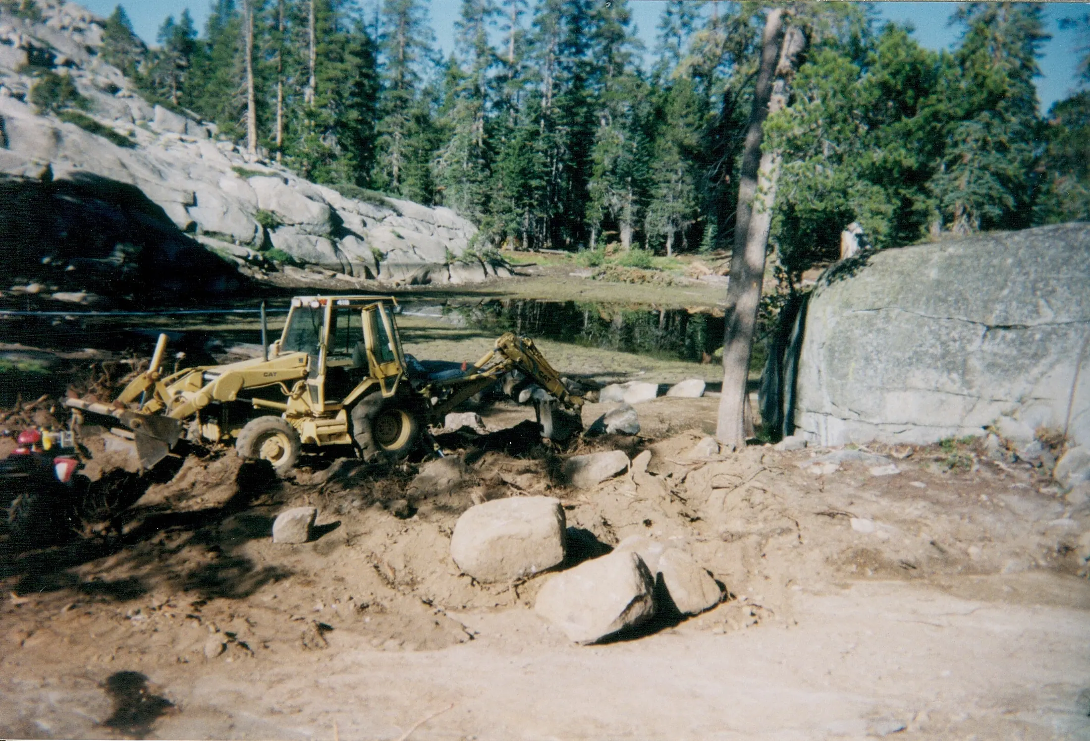 An excavator working the raw granite site before the lodge was built.