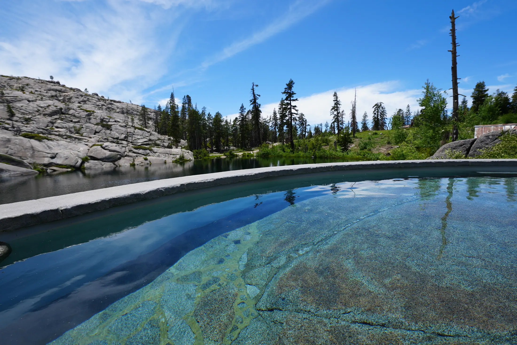 The heated granite hot tub cut into the rock above the lake.